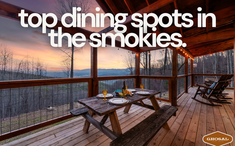 A wooden picnic table set for dinner sits on a covered deck overlooking mountains at sunset, with text reading top restaurants Smoky Mountains. The cozy, rustic scene offers scenic views and highlights must-visit Smokies dining spots.