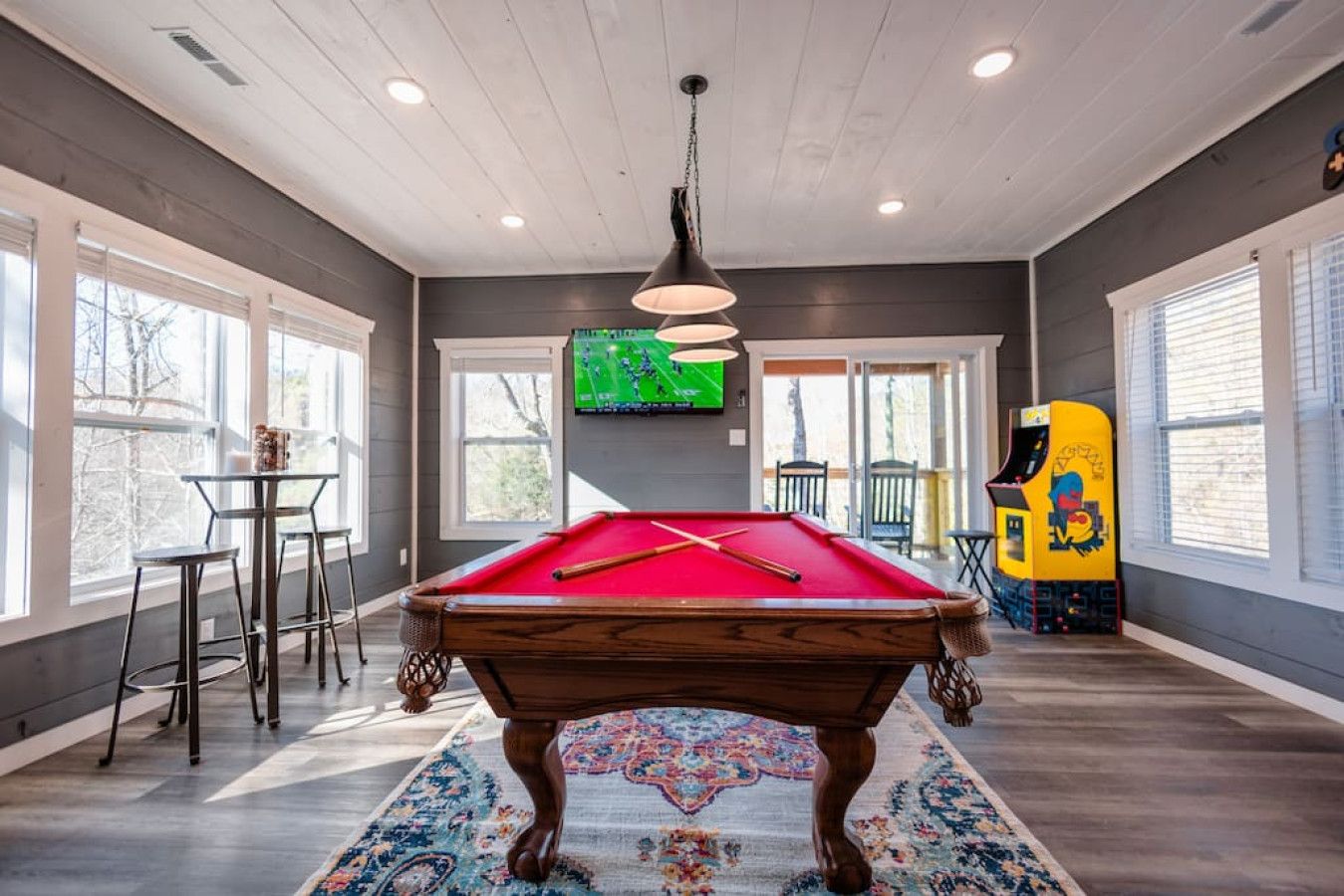 Gaming room including a pool table, two arcade games, and a large HDTV.