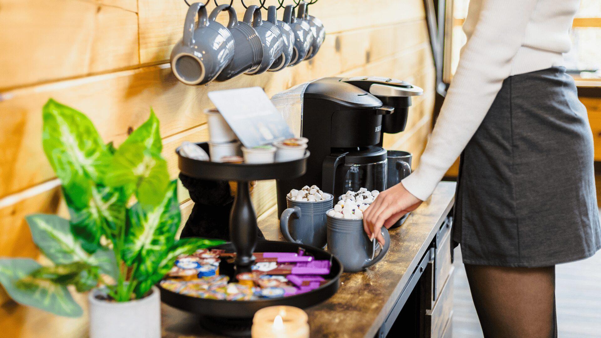 A woman making hot chocolate next to a machine.