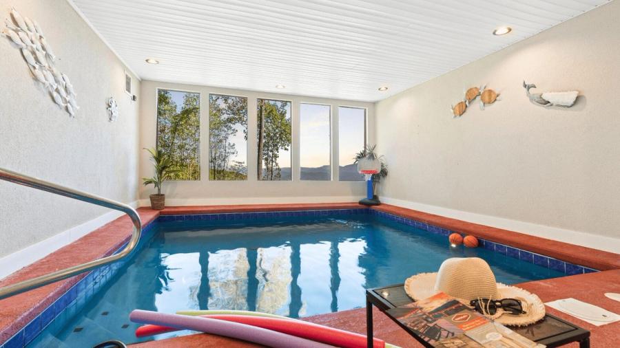 An indoor pool with a view of the valley.