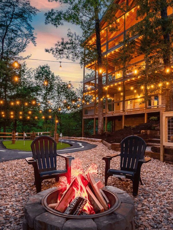 An outside area with chairs positioned around a fire.