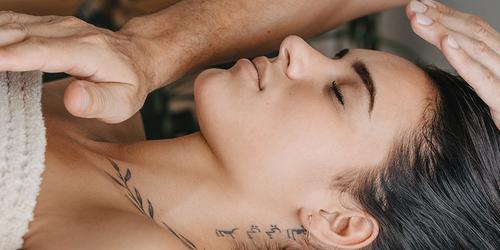 A woman receiving a Reiki session