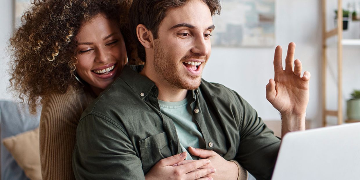 Couple happily connecting during a video call, symbolising love