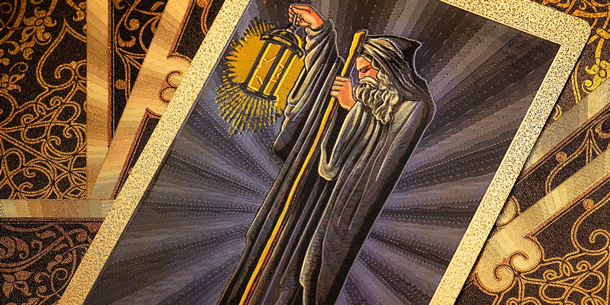 A gold version of the Hermit Tarot card.