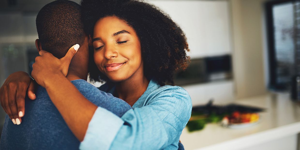 Two soulmates embracing each other in their kitchen.