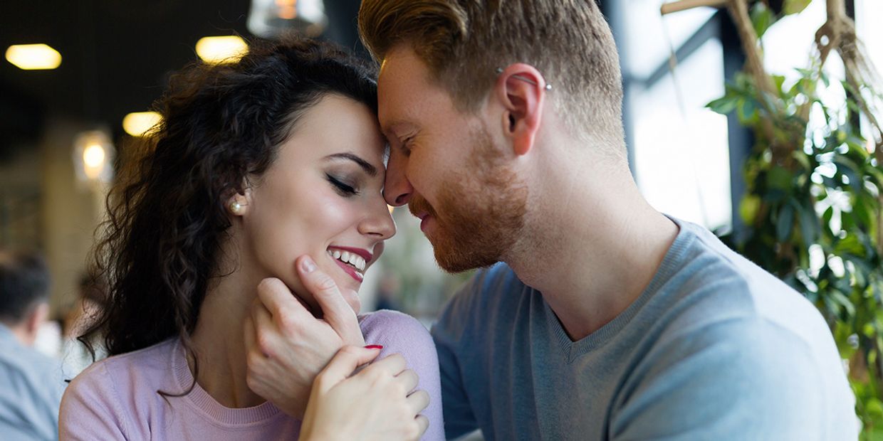 A young couple in love, embracing in a cafe.