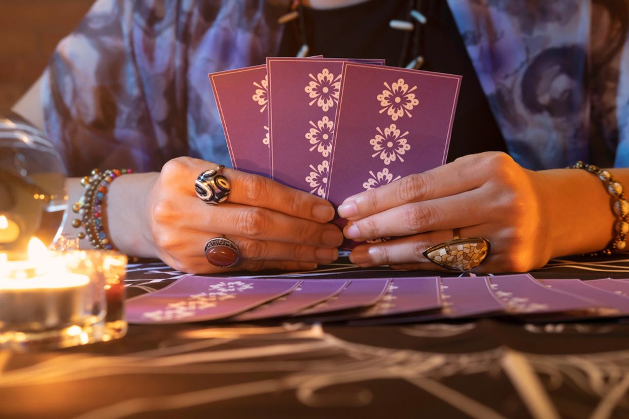 A tarot reader holding tarot cards