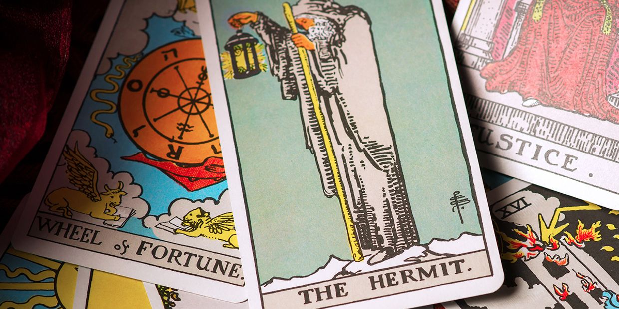 The Hermit Tarot card lying on other Tarot Cards.