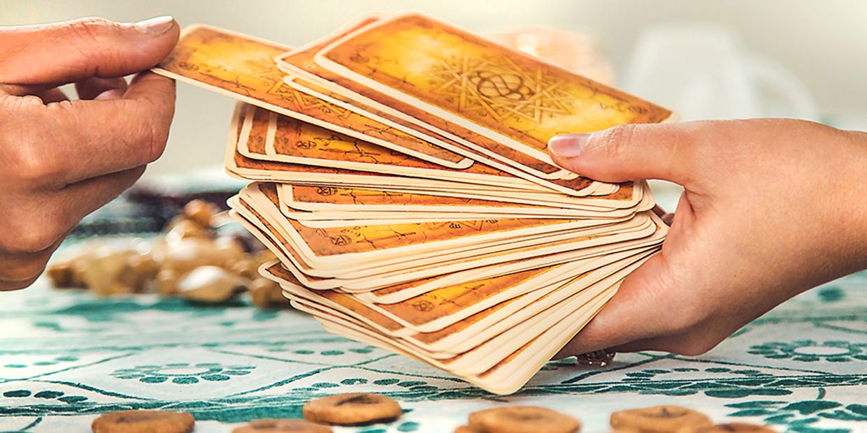 A deck of tarot cards being held by a tarot reader.