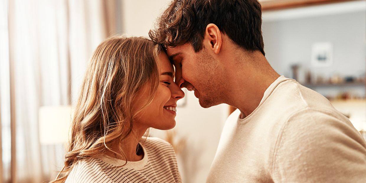 A young couple in love, embracing in their living room