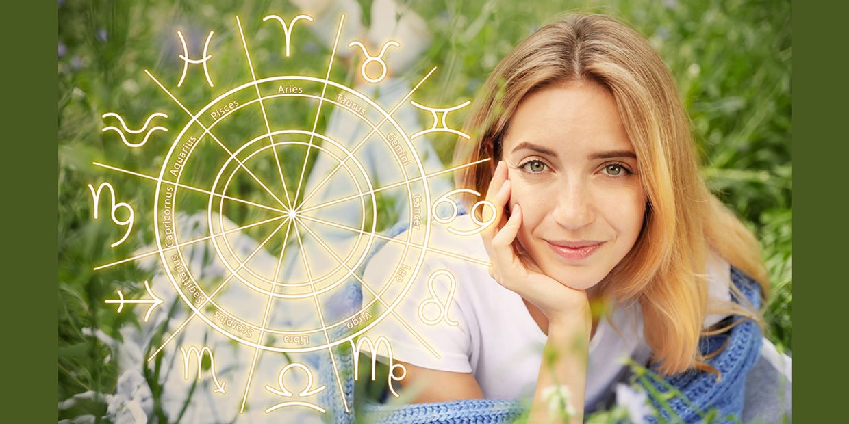 An astrology wheel, showing the zodiac signs with a beautiful woman in the background.