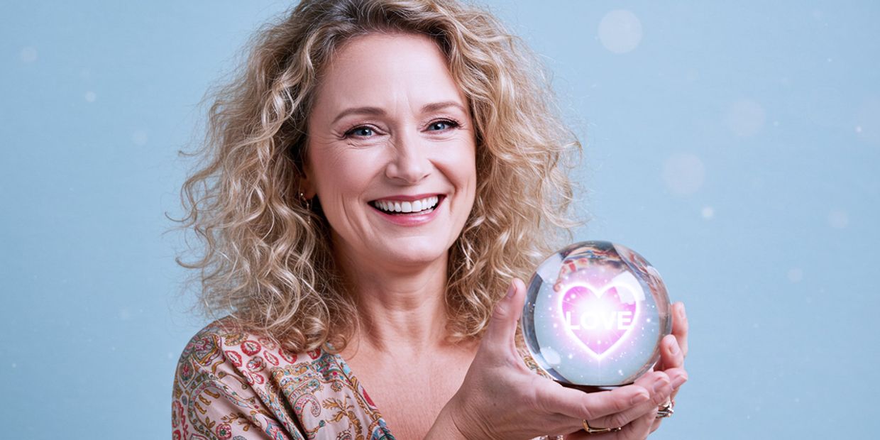 A Love Tarot reader holding a crystal ball and smiling.
