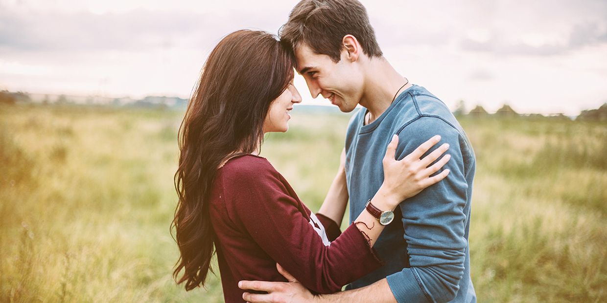 Psychic Love Reading - A young couple embracing in a field.