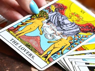 A Tarot card featuring 'The Lovers' from a Tarot deck for reconciliation guidance.