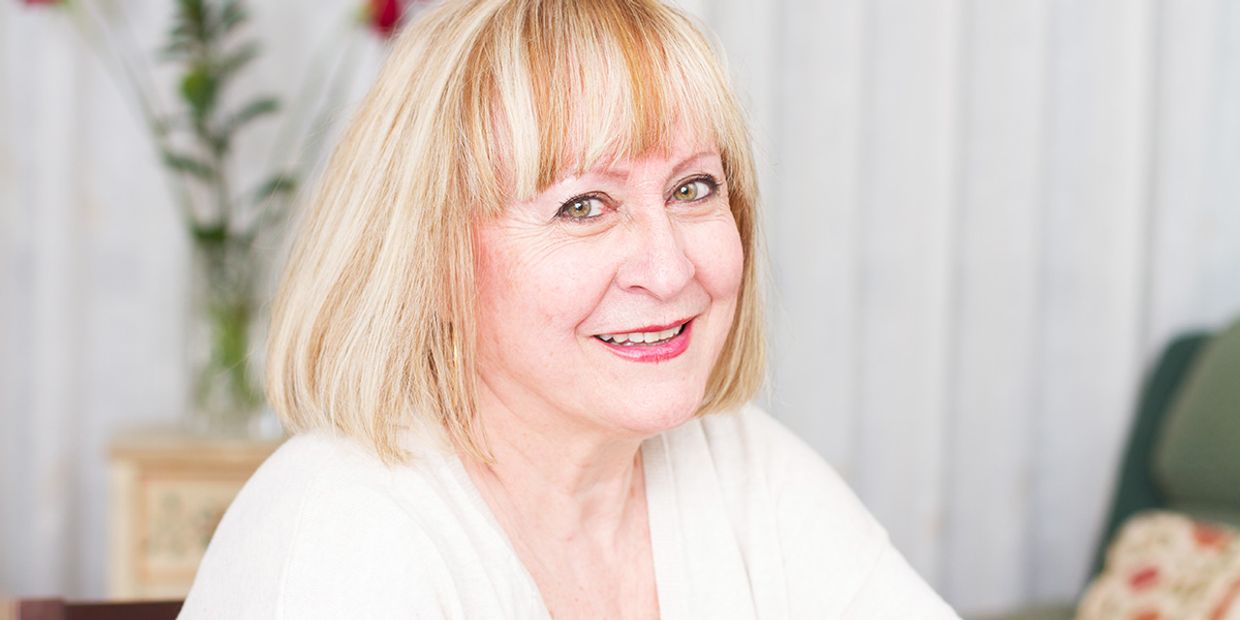 A smiling psychic offering love advice in a cozy setting.