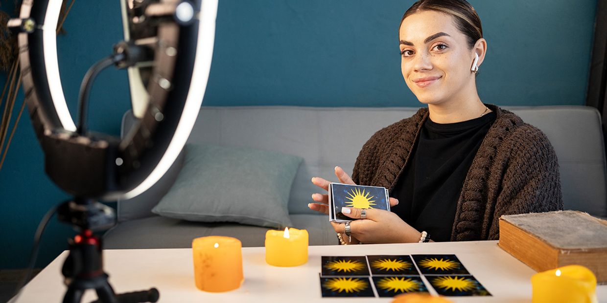 A psychic offering love advice with tarot cards and candles.