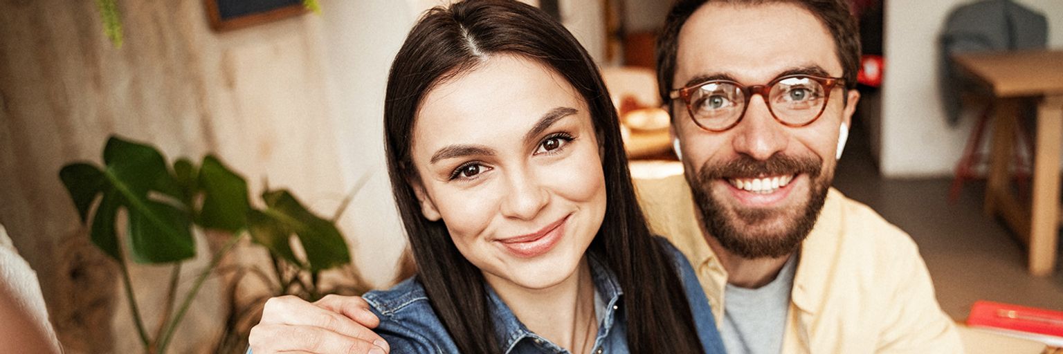 Illustration of a smiling couple sitting together at home, leaning towards each other, and looking into each other’s eyes with a happy relationship, love emotions and connection energy theme.