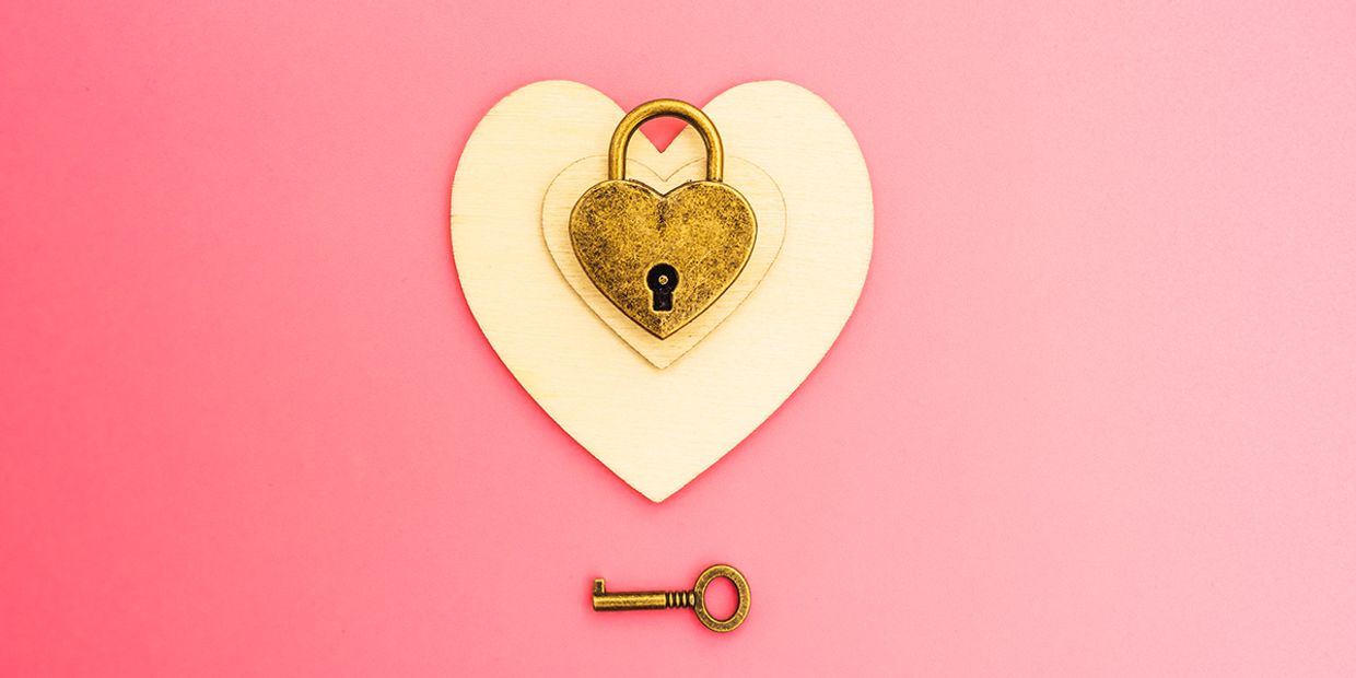 A heart-shaped padlock on a wooden heart, symbolising love and connections.