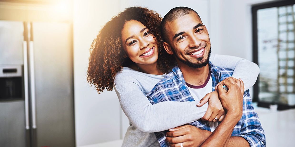 Psychic Love Reading - A happy couple, in love, in their kitchen, embracing.