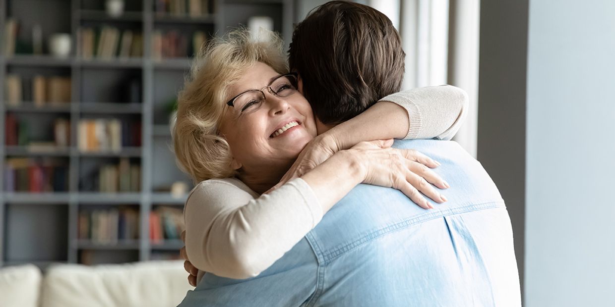 Mother and adult son embracing