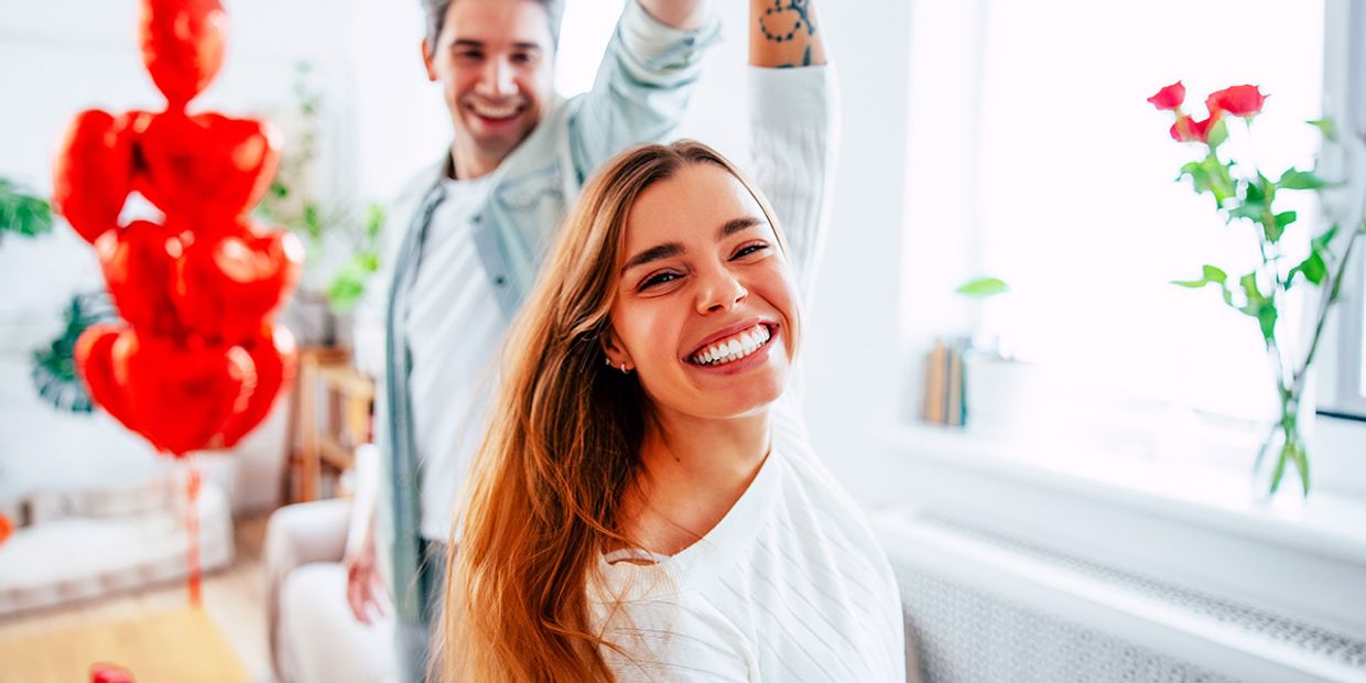 Happy couple celebrating love after psychic insights and red balloons.