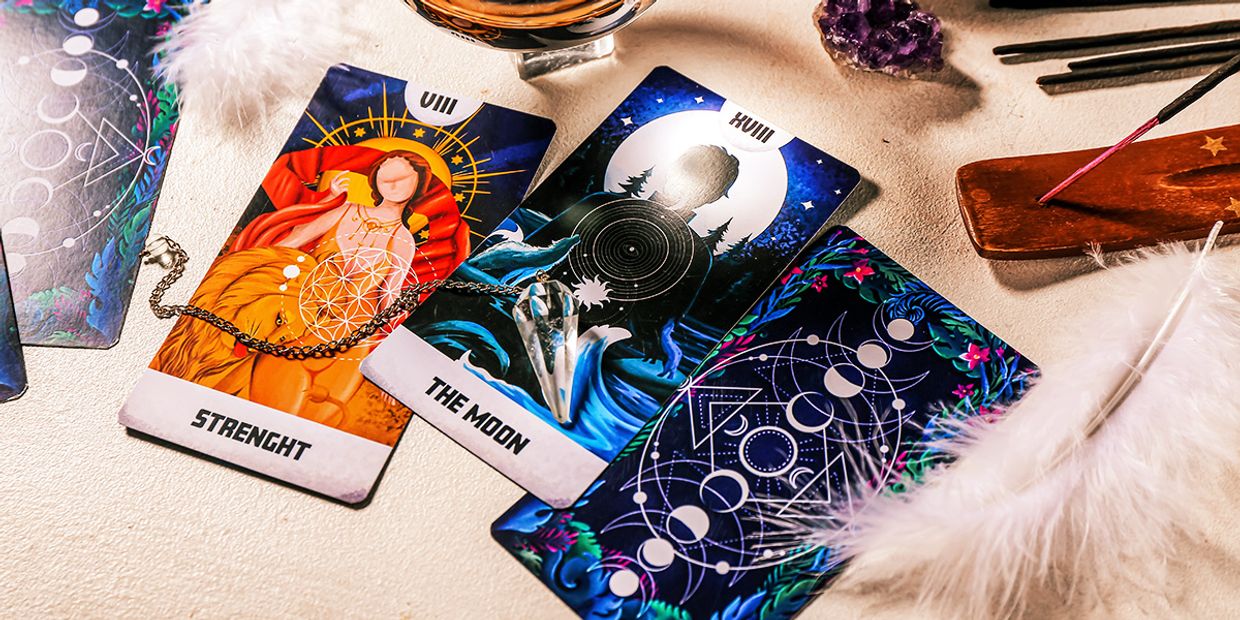 The Strength and The Moon Tarot Card, lying on a table.