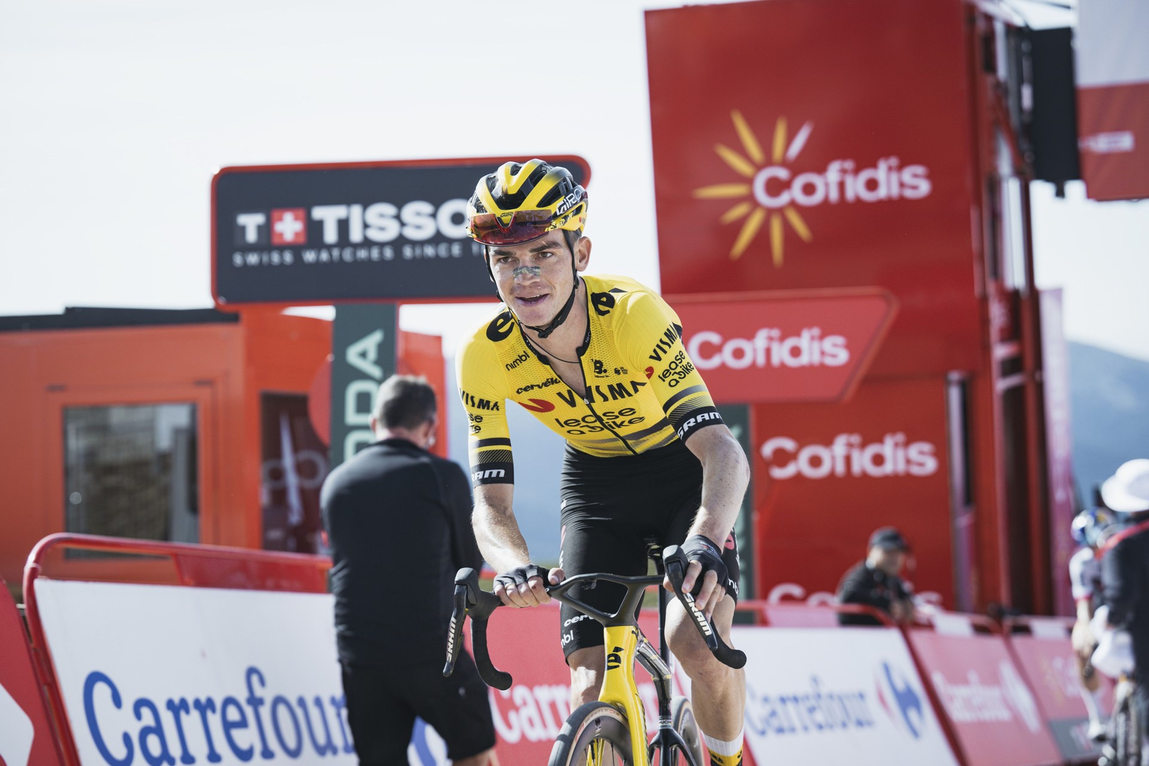 Cyclist ascends steep mountain road in Vuelta with spectators and peaks, the Vuelta is set to be cut from NOS's coverage