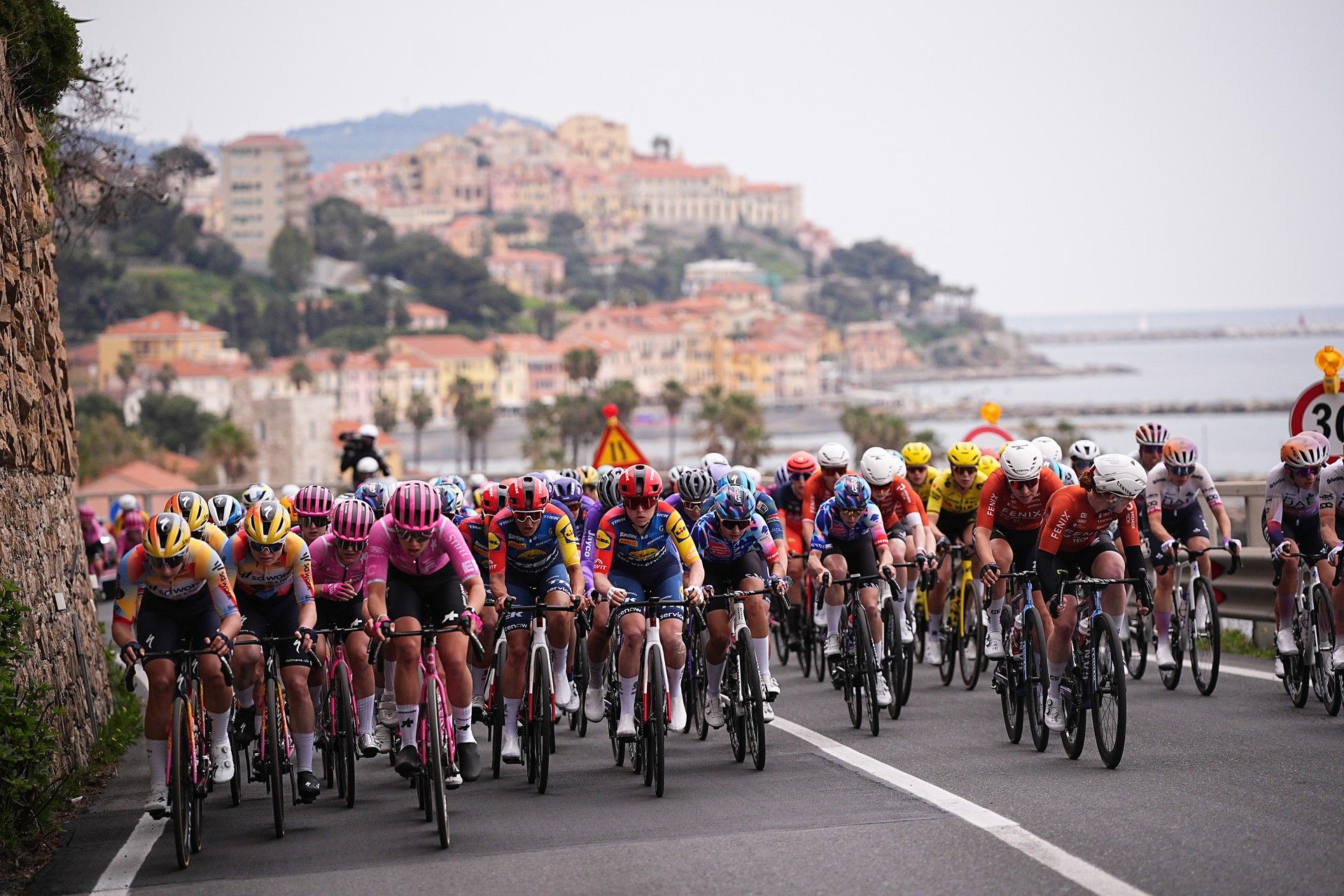 Peloton of women cyclists racing on coastal roads in Sanremo during the Sanremo Women one-day race.