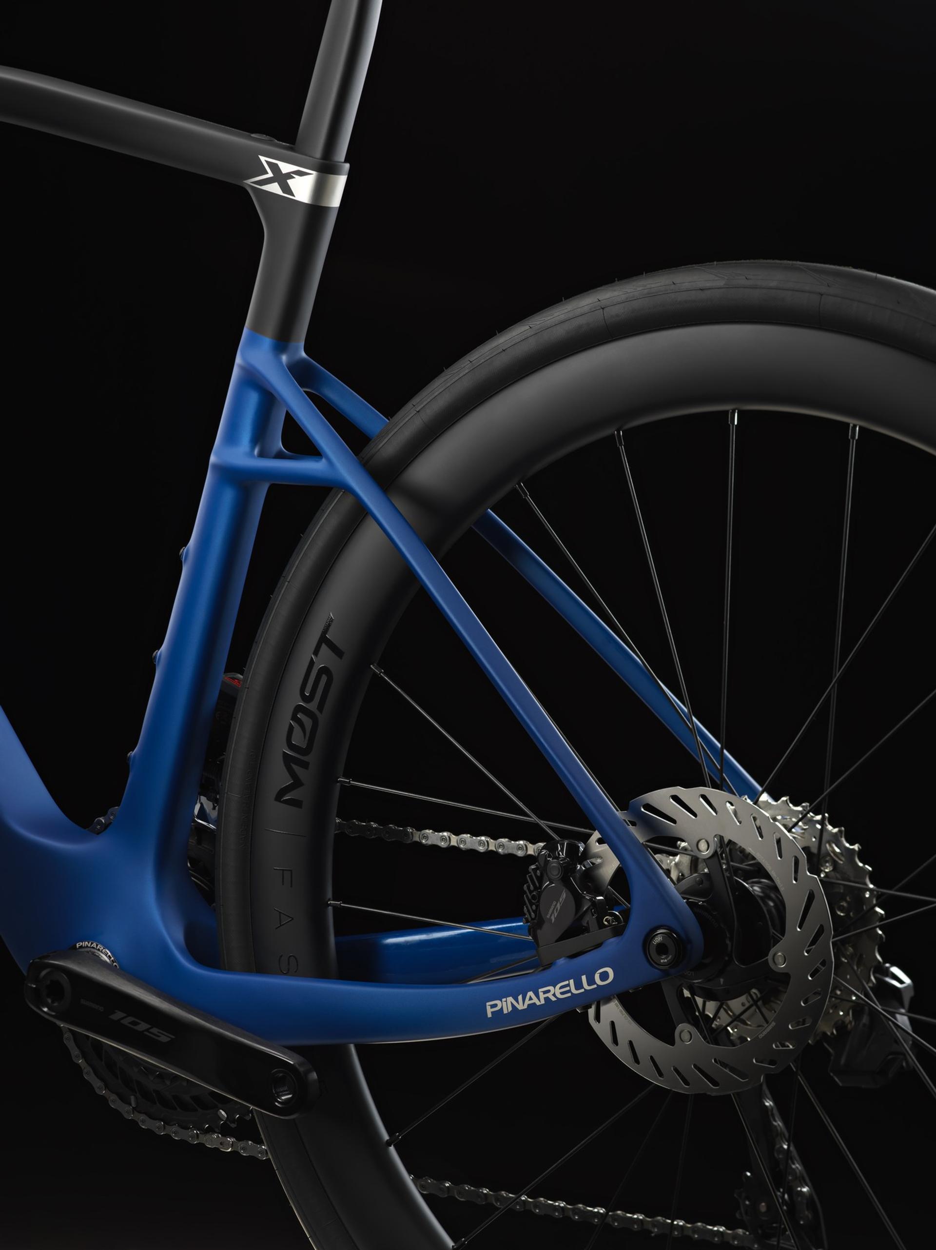 Close-up of a blue Pinarello X Series road bike’s rear wheel, disc brake and drivetrain