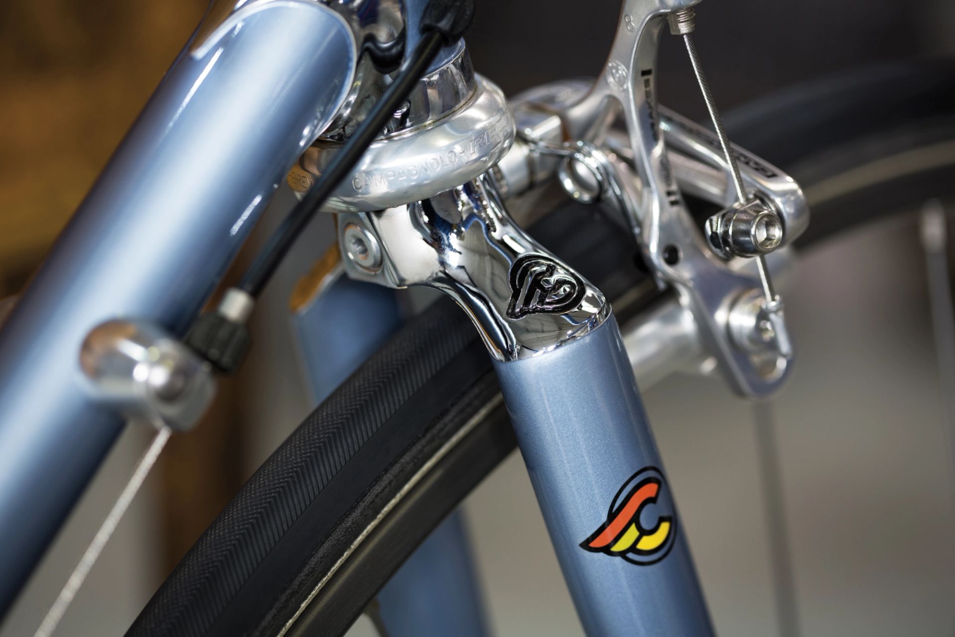 Close-up of the front fork and rim brake on a Cinelli Supercorsa steel road bike, showing a chromed fork crown, caliper brake and narrow road tyre.