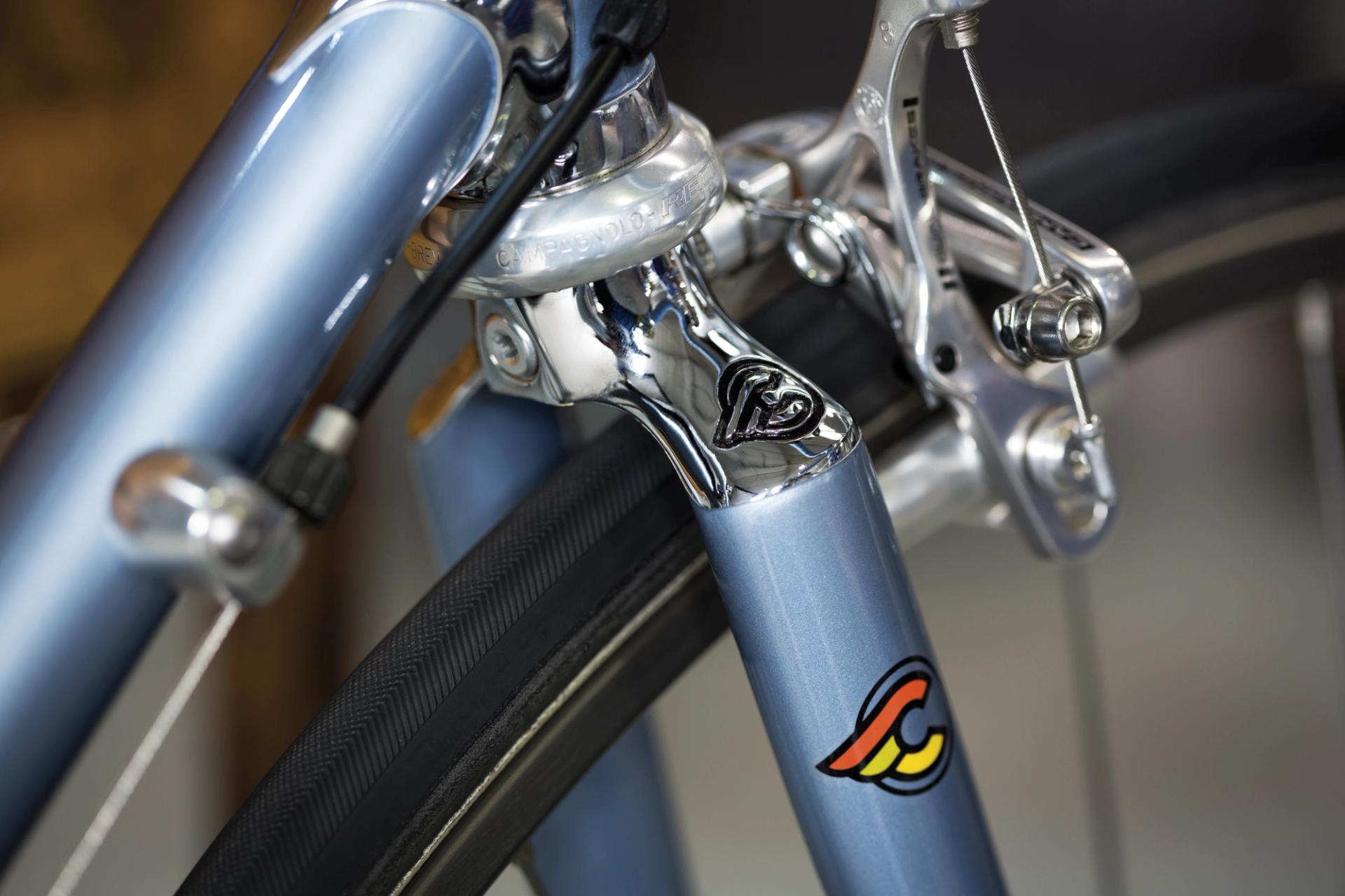 Close-up of the front fork and rim brake on a Cinelli Supercorsa steel road bike, showing a chromed fork crown, caliper brake and narrow road tyre.