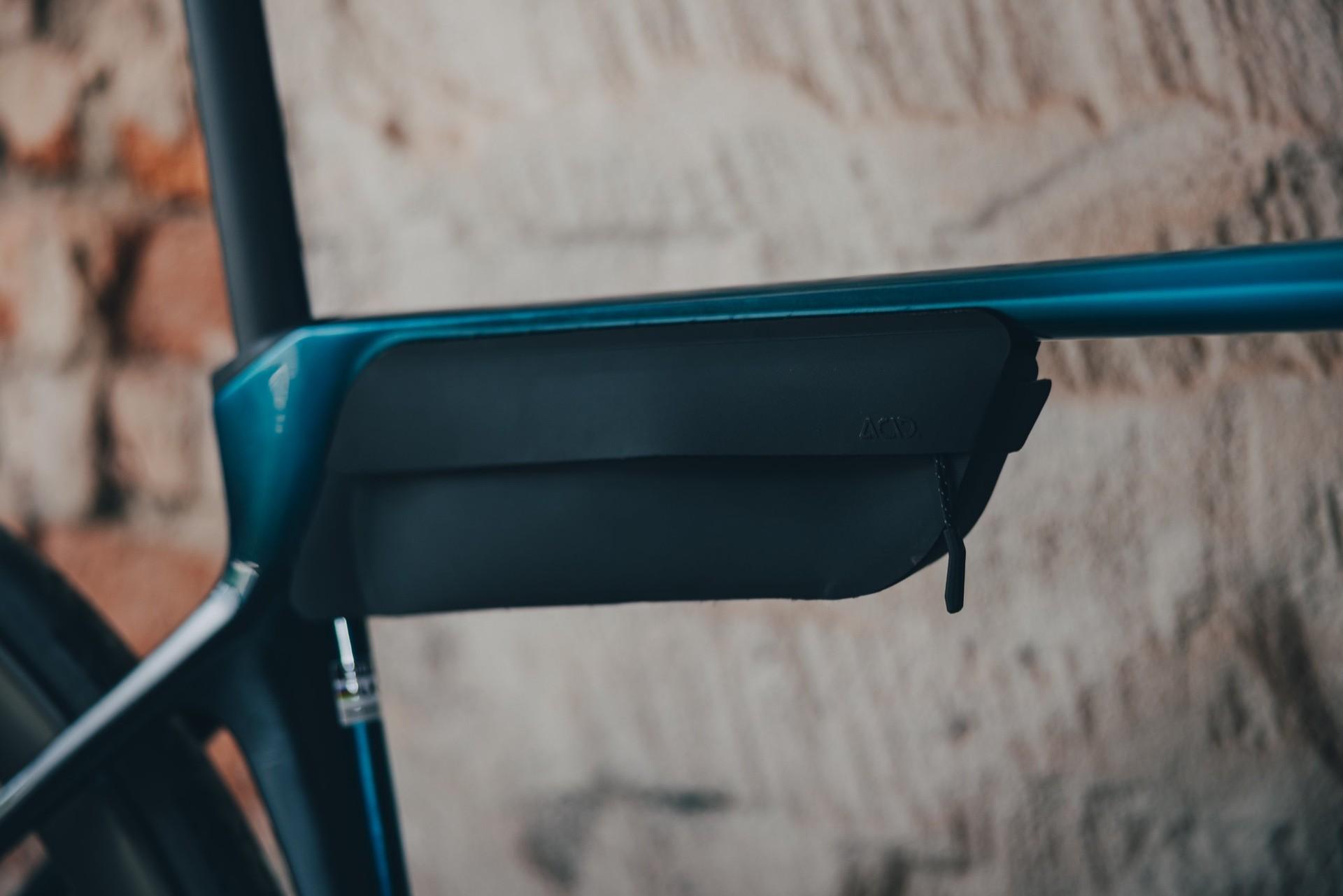 Close-up of the Cube Agree’s black frame storage box beneath the top tube, against a brick wall