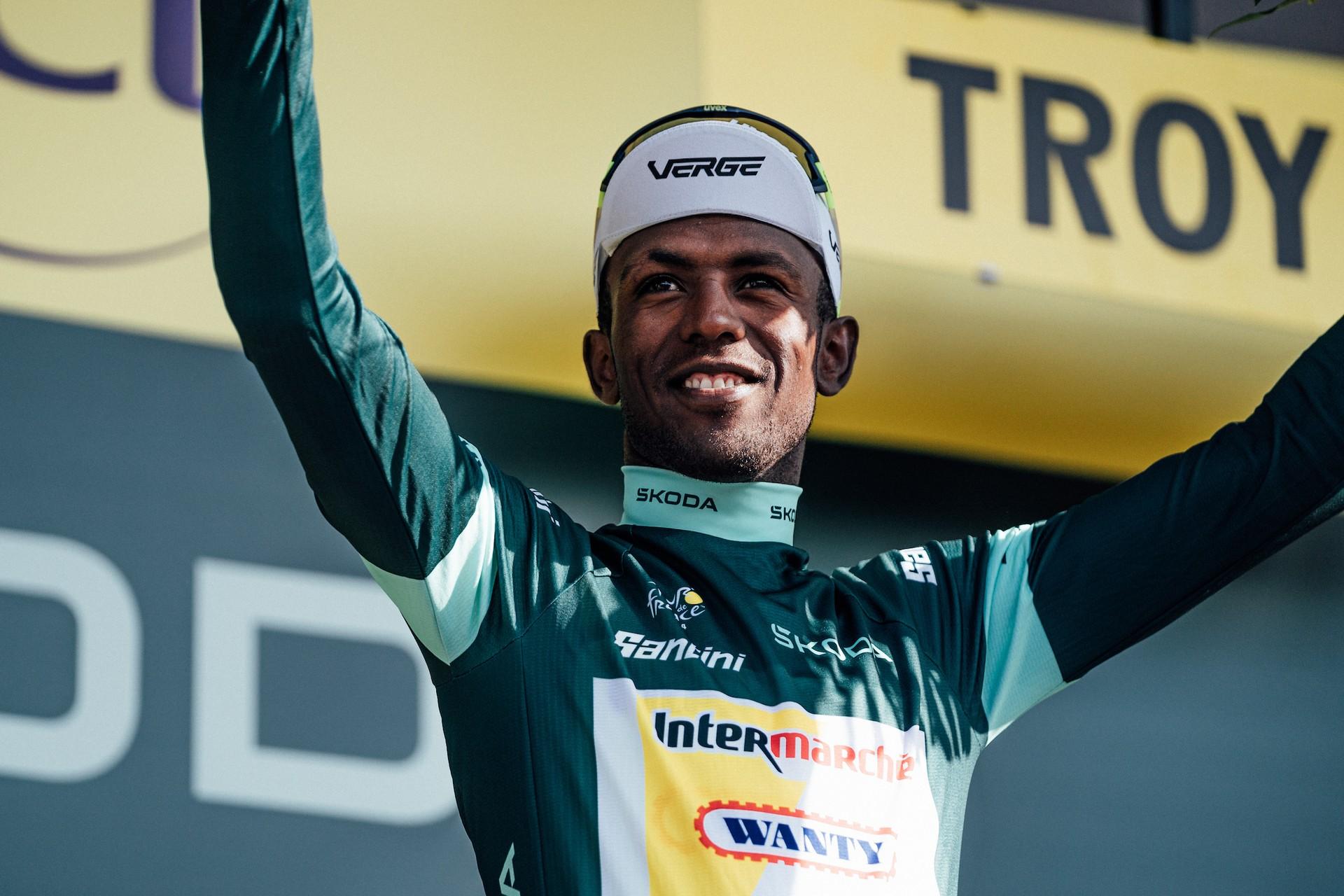 Biniam Girmay celebrates on the podium wearing the green jersey during the Tour de France in Troyes.