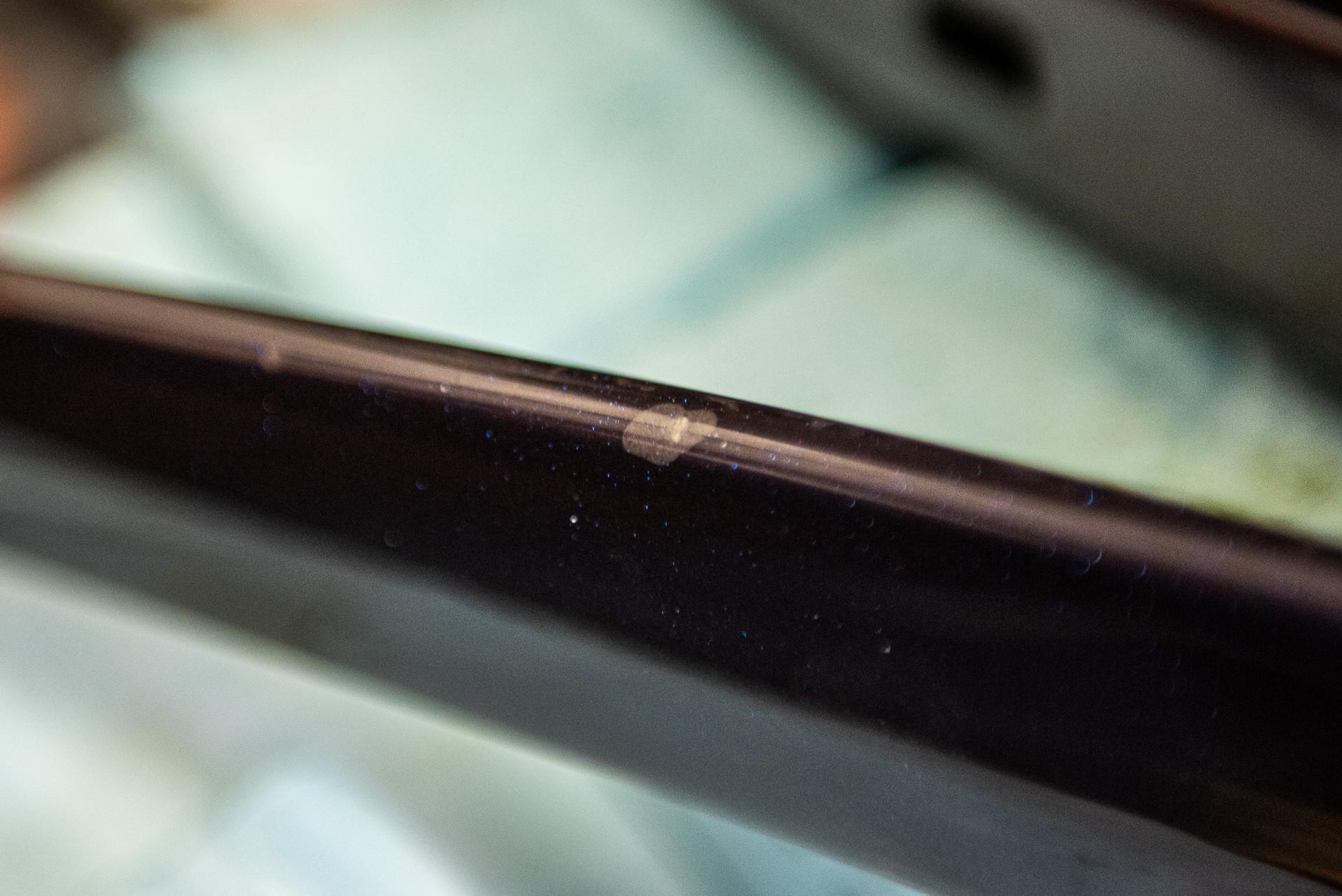 Close-up of a bicycle handlebar and seat tube with dust and wear along the frame