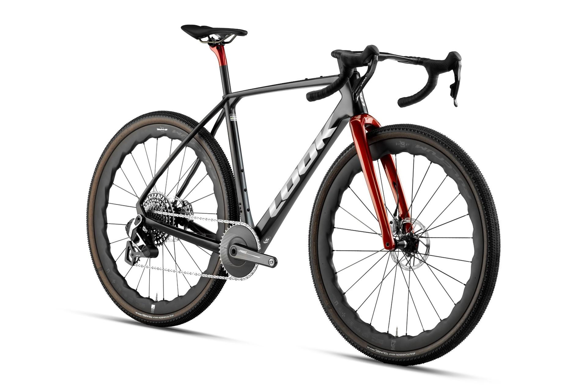 Side-view illustration of a black gravel bike with red fork blades and deep-tread tires.