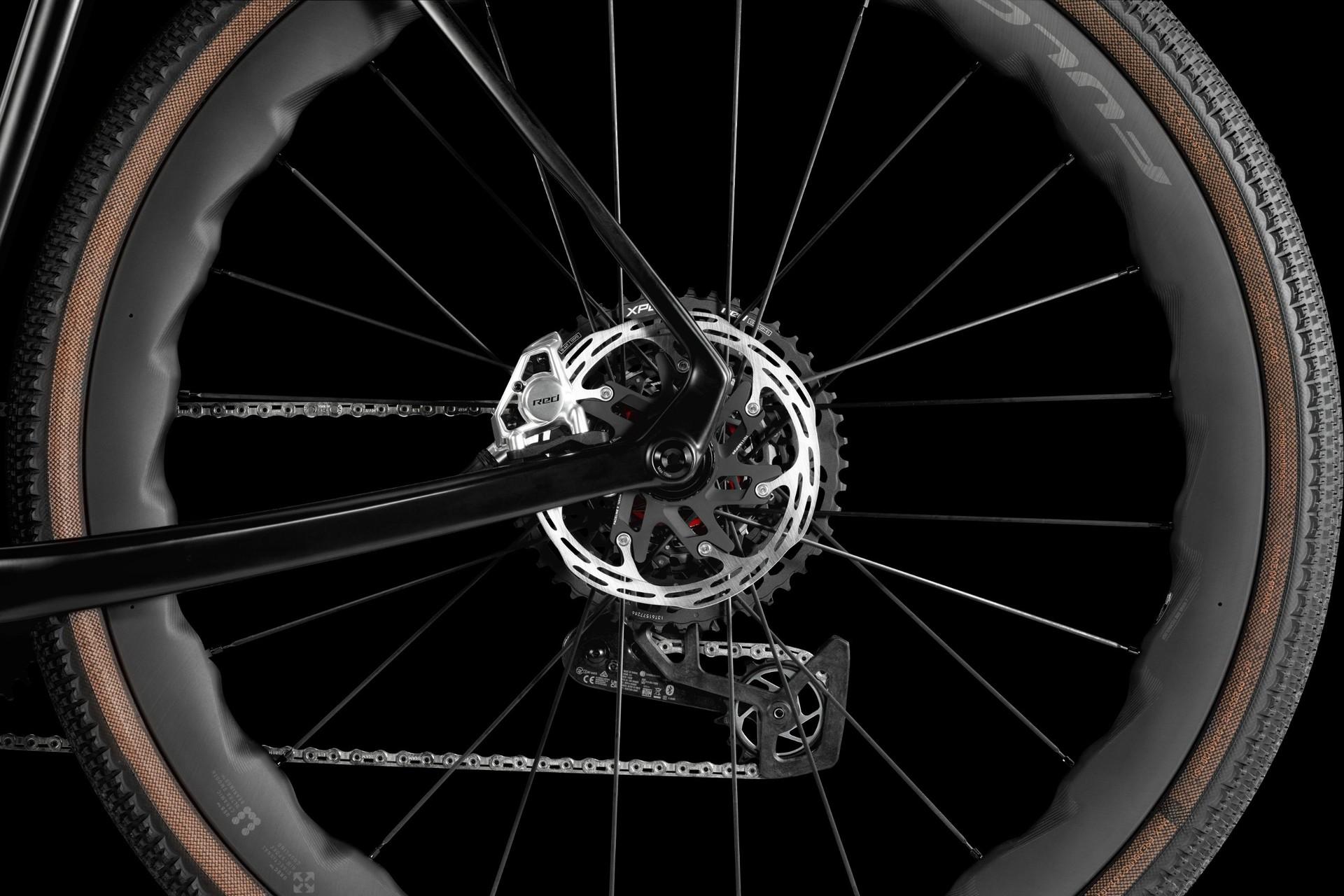 Technical drawing of a bicycle wheel and rear frame assembly, with radial lines on a black background.