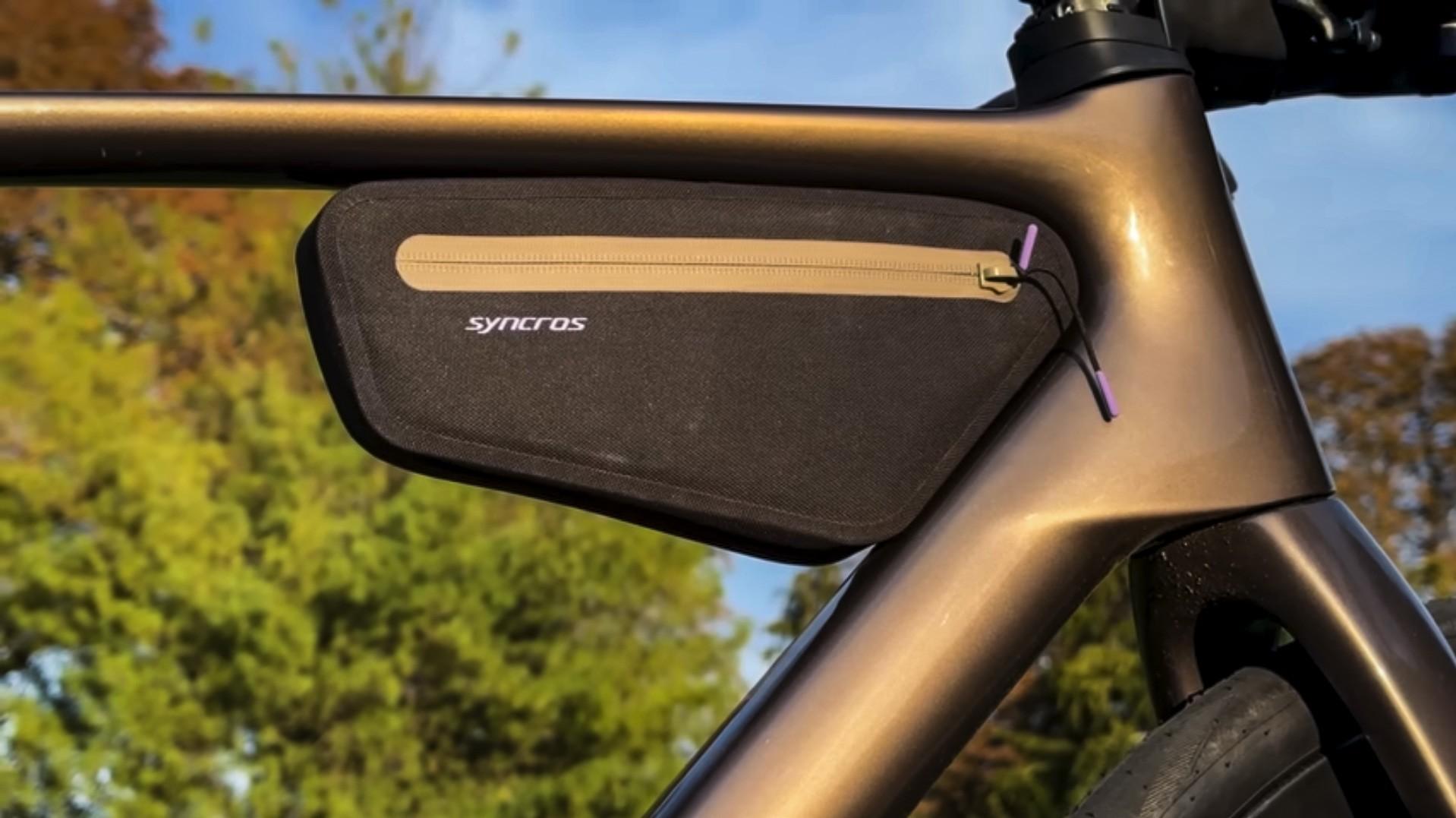 Syncros frame bag mounted on a bronze-colored bicycle frame with autumn trees in the background.