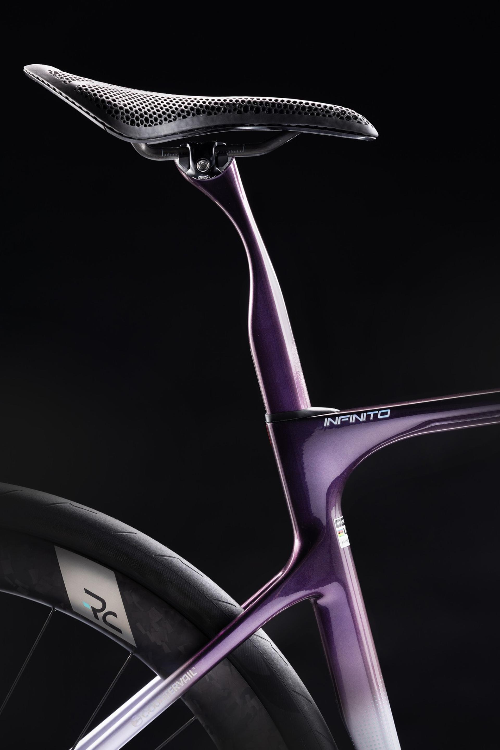 Close-up of a Bianchi Infinito road bike featuring a purple carbon frame and 3D-printed honeycomb saddle.
