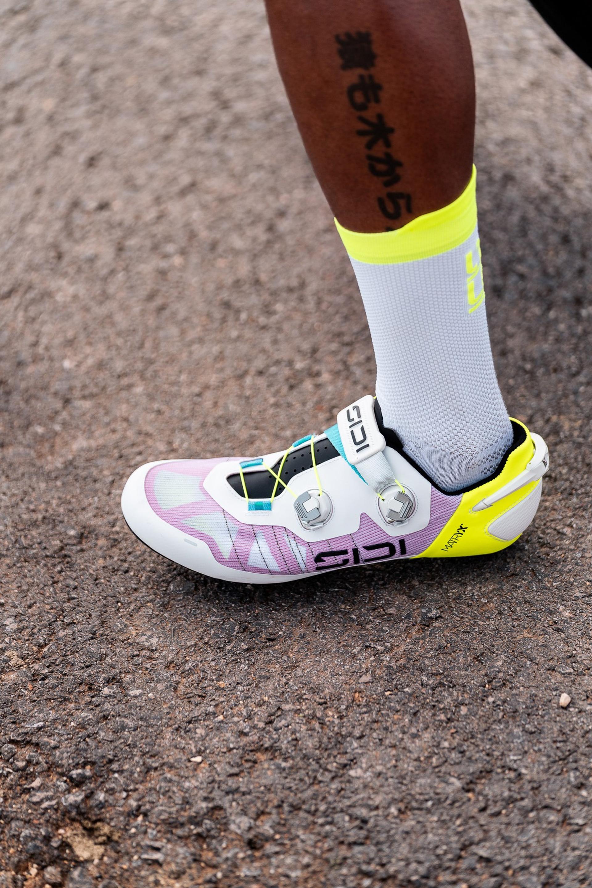 Cyclist’s shoe and sock on a road, close-up of a pedaling moment