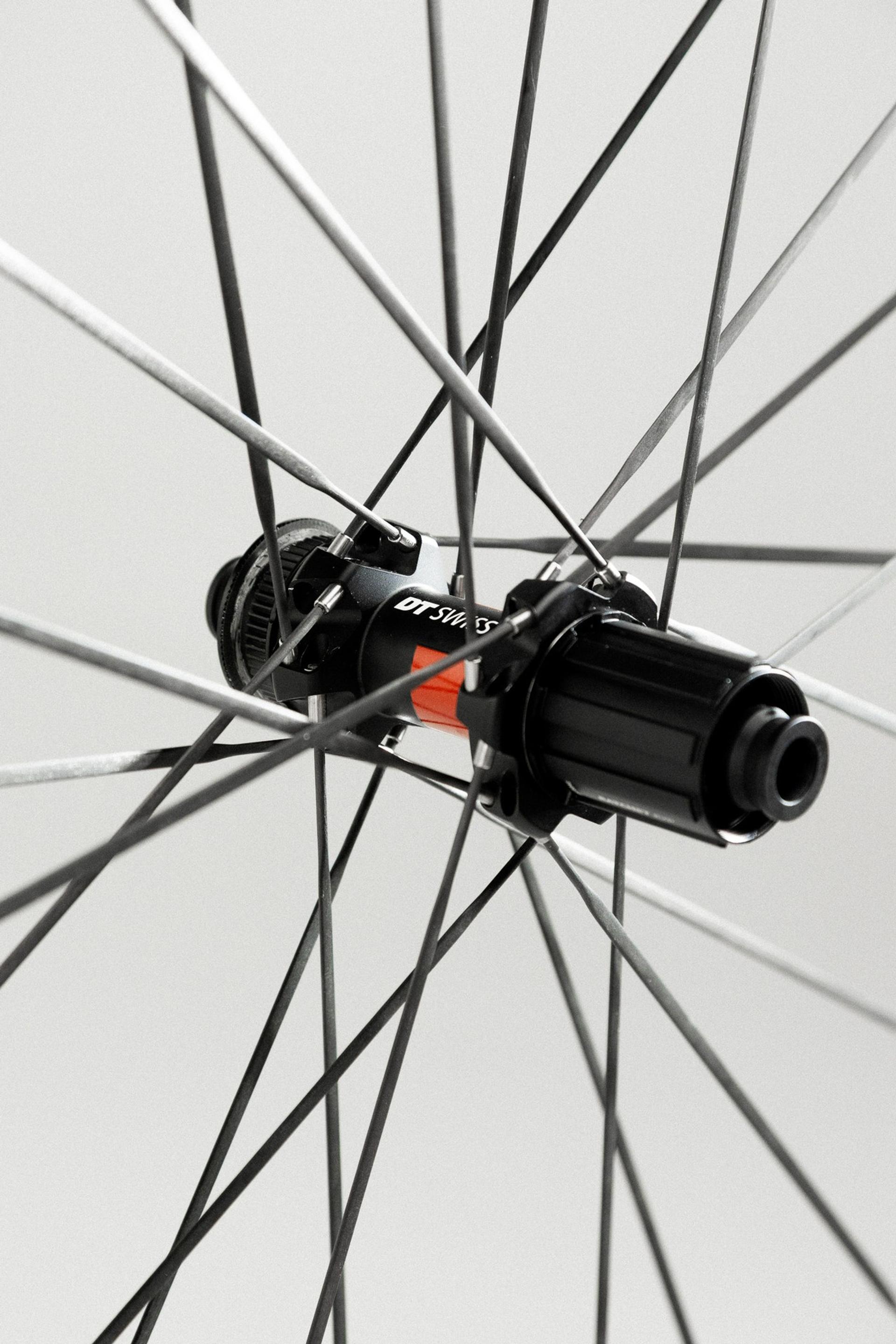 Close-up of a black bicycle wheel hub with carbon spokes