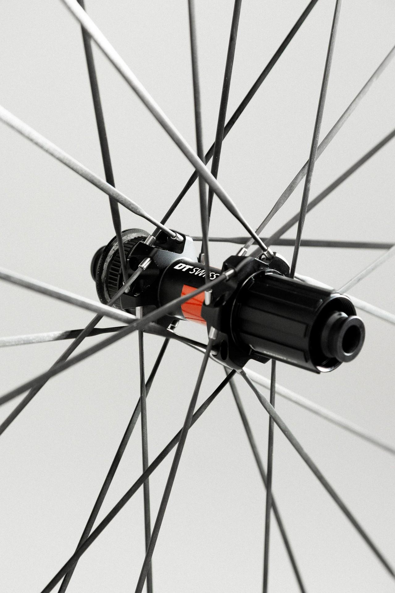 Close-up of a black bicycle wheel hub with carbon spokes