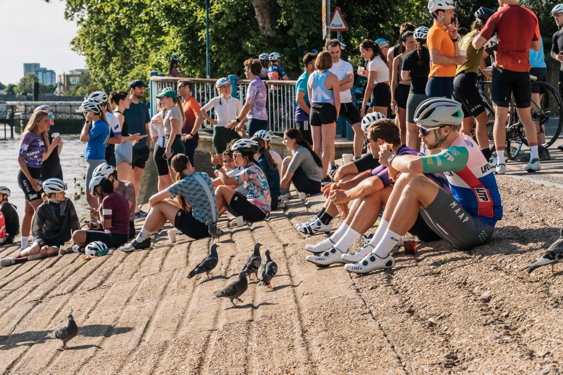 Cyclists spilling out onto the riverbanks of the Thames outside The Clubhouse café