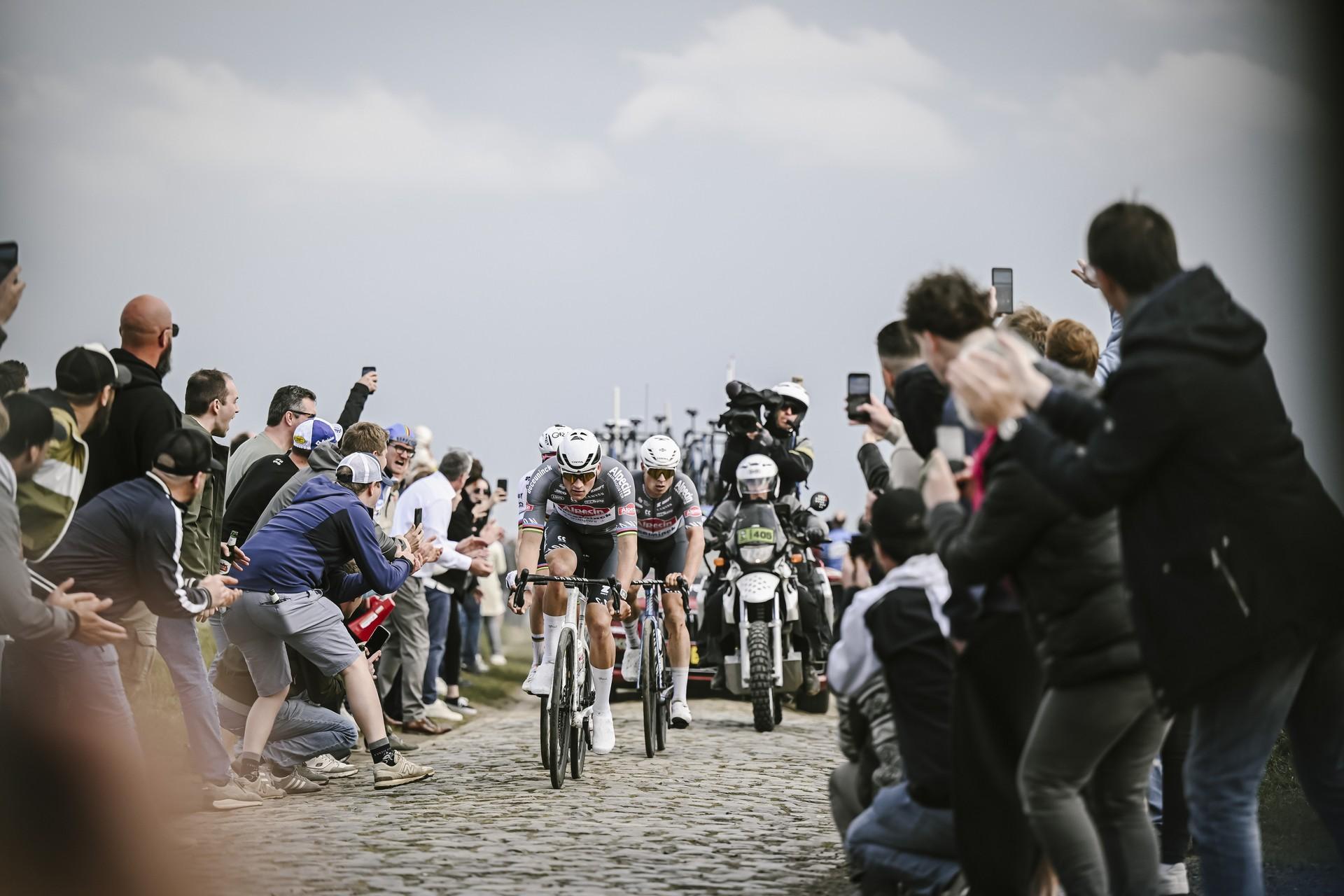 Philipsen and rider navigating Paris-Roubaix cobbles with roadside crowds