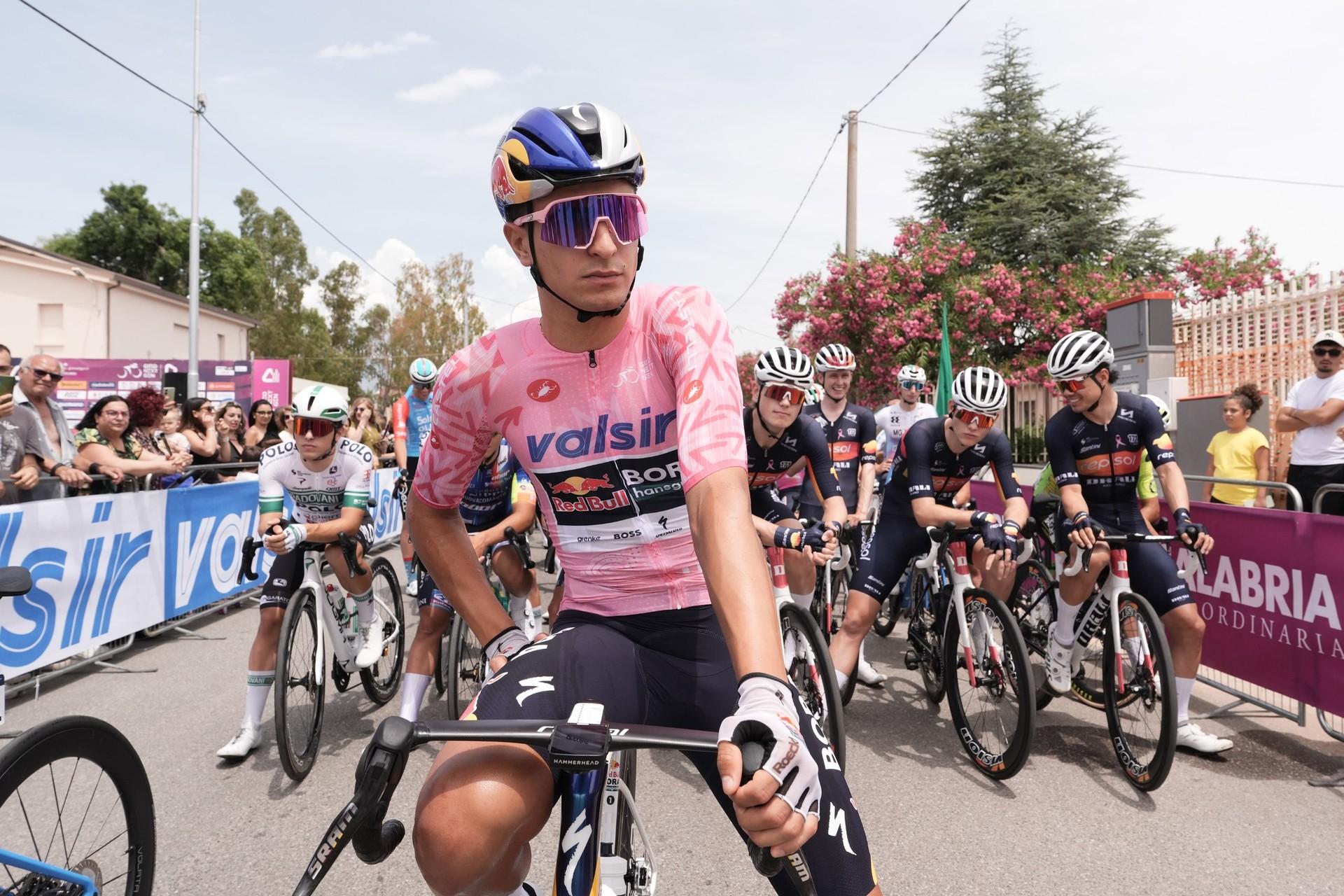 Davide Donati in a pink leader’s jersey at the front of a lineup of cyclists