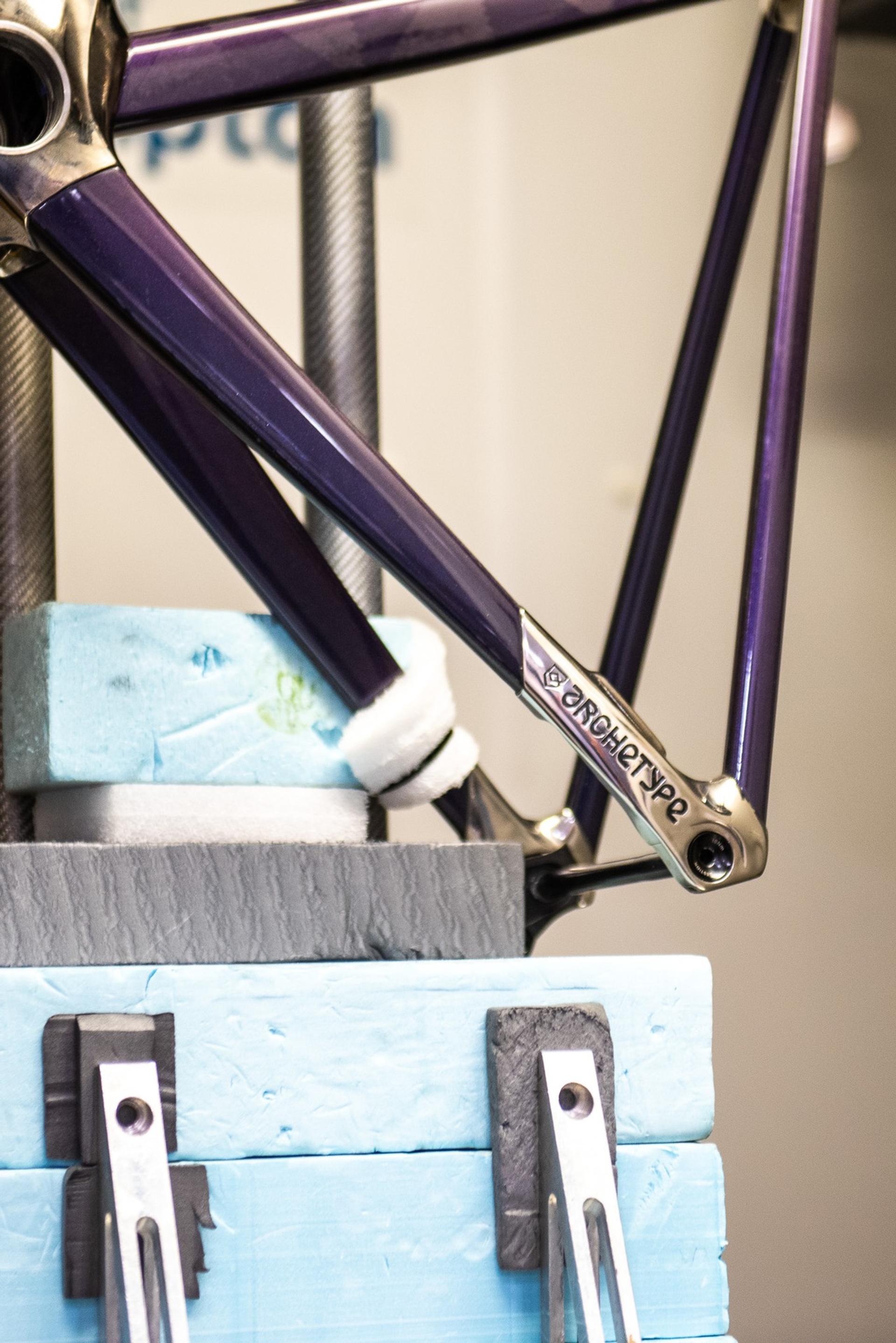 Close-up of a purple racing bicycle frame with a chainstay and crank area detail