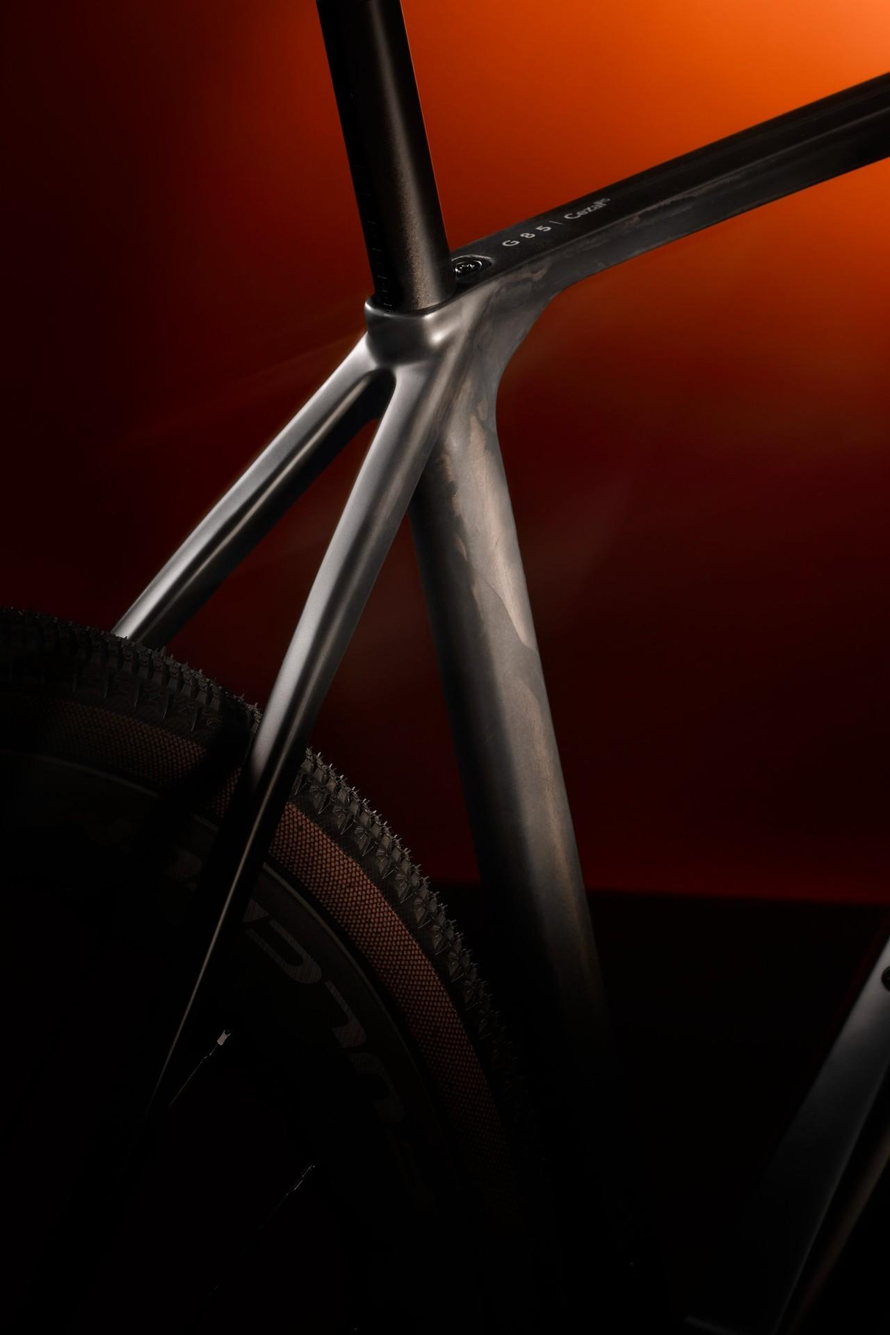 Close-up of the Look G85 Cezal RS frame junction, with its fork and front wheel against an orange backdrop.
