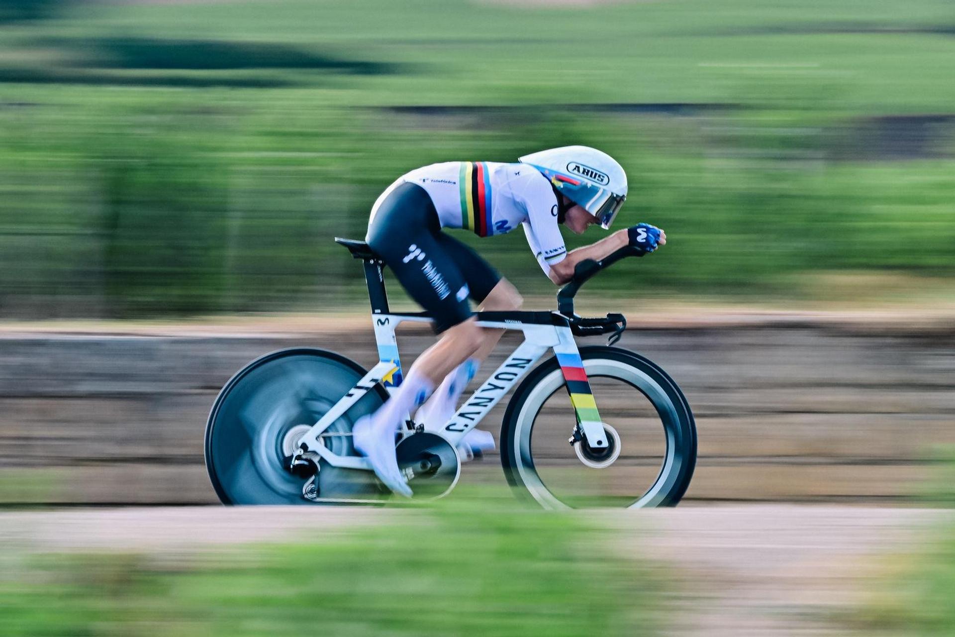 Cyclist racing in an aerodynamic time-trial position on a road bike