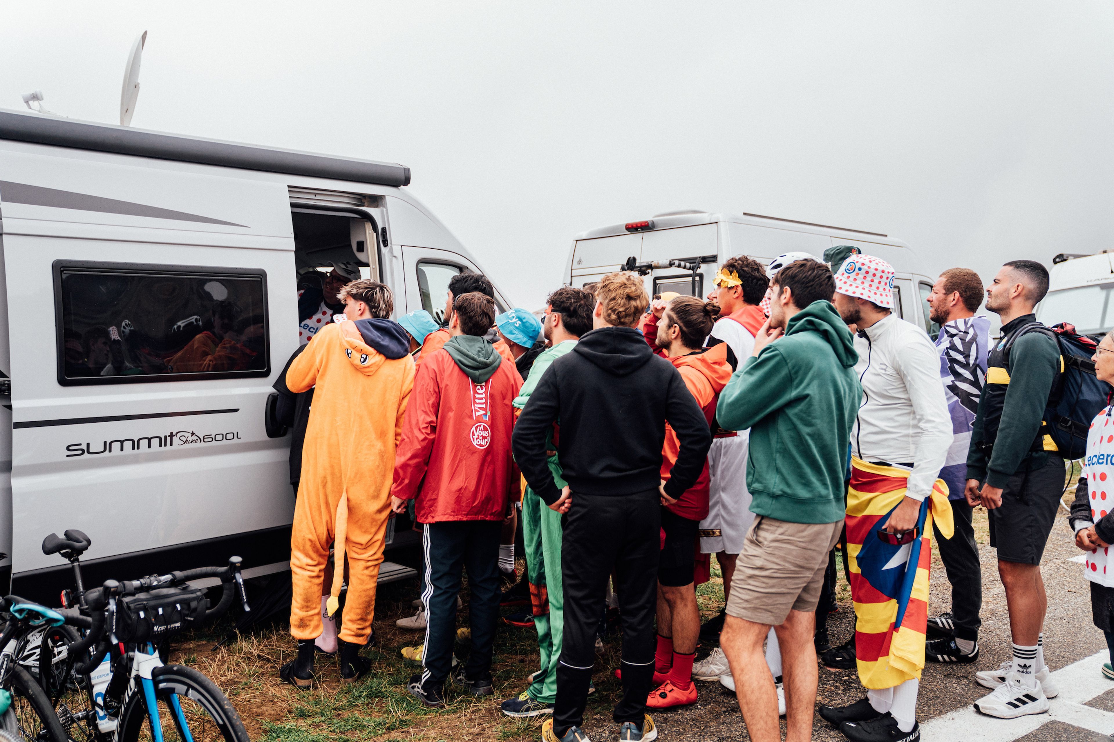 Picture by Zac Williams/SWpix.com - 19/07/2025 - Cycling - 2025 Tour de France Stage 14, Pau - Luchon-Superbagneres, France - Fans crowd around a campervan TV to watch the finish.