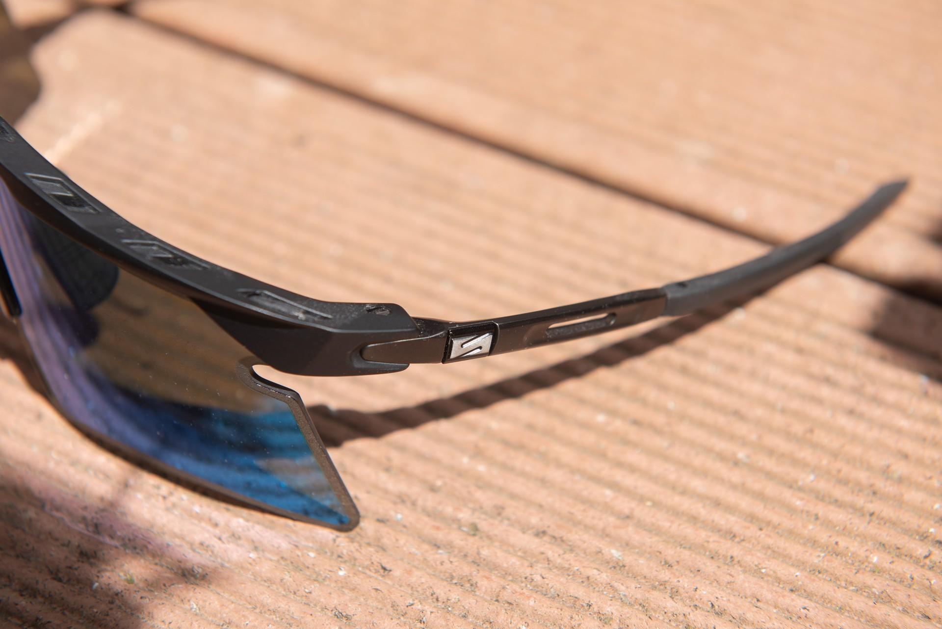 Close-up of a cyclist’s aerodynamic sunglasses on a road pavement surface
