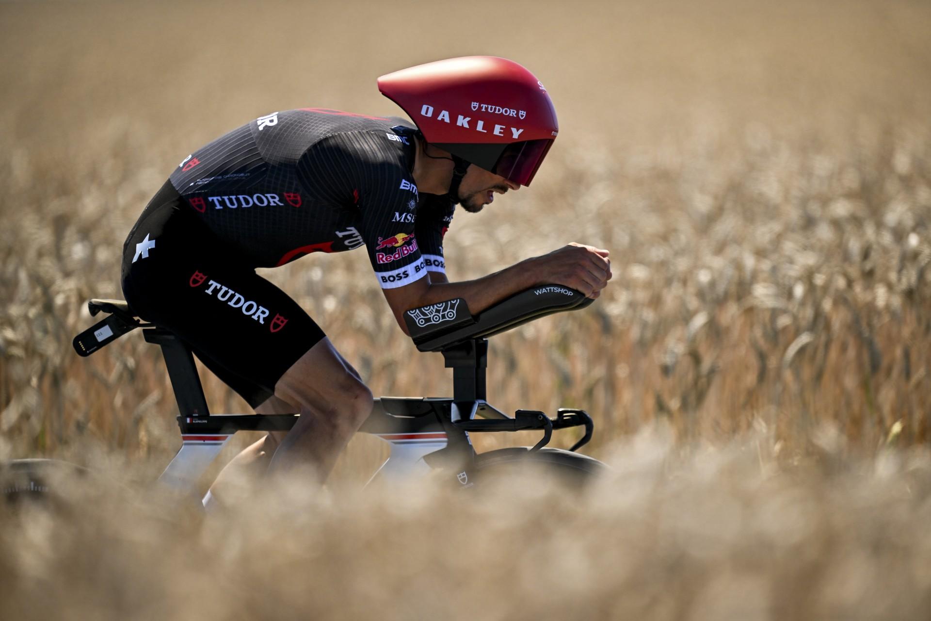 Alaphilippe (Tudor) in aero TT position riding through golden fields during Tour de France.